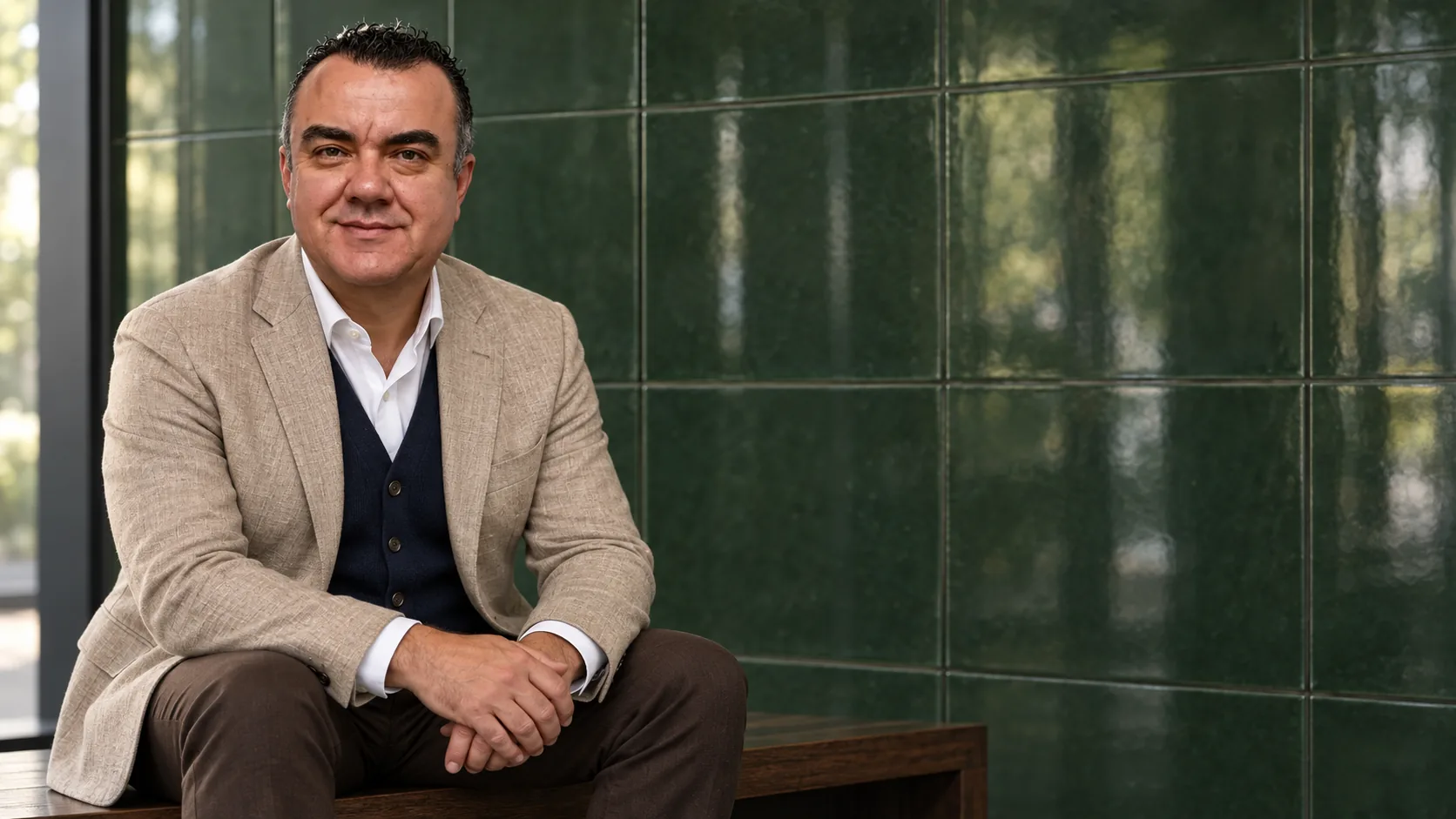 Stuart Newman seated against a green ceramic wall